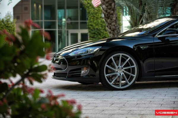 Tesla modelo s en el fondo de la fachada del edificio