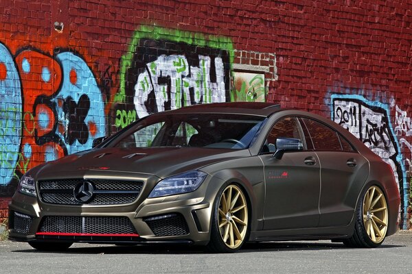 Mercedes-benz w218 y graffiti en una pared de ladrillo