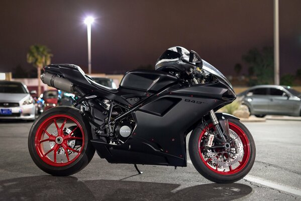 Moto ducati negra en el estacionamiento nocturno