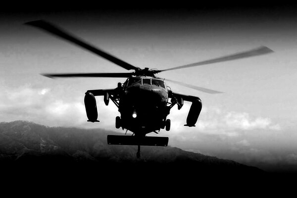 Black and white photo of a military helicopter in the air