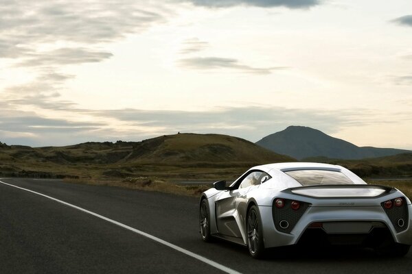 Silver Zenvo corre in lontananza lungo la strada suburbana