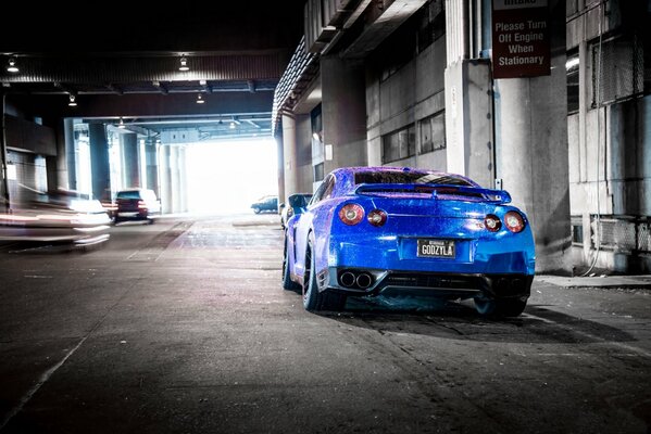 Nissan di colore blu in piedi alla colonna