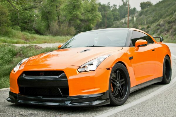 Orange nissan gtr entered a sharp turn on the road