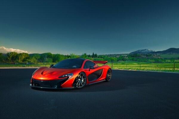 McLaren rojo contra el paisaje verde