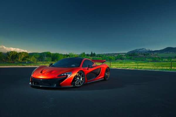 Mclaren rouge sur fond de paysage vert