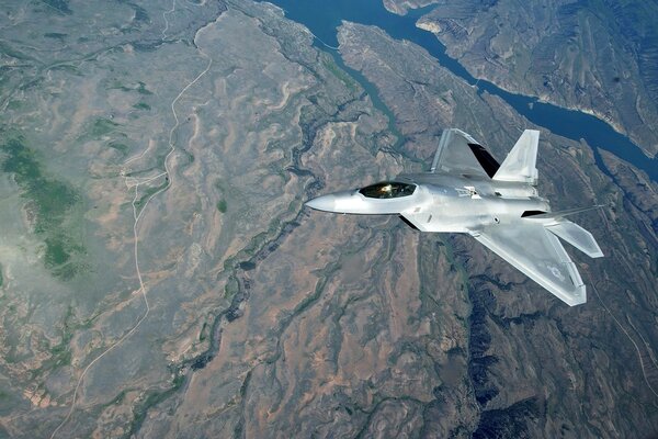 Самолет f-22 над земной поверхностью