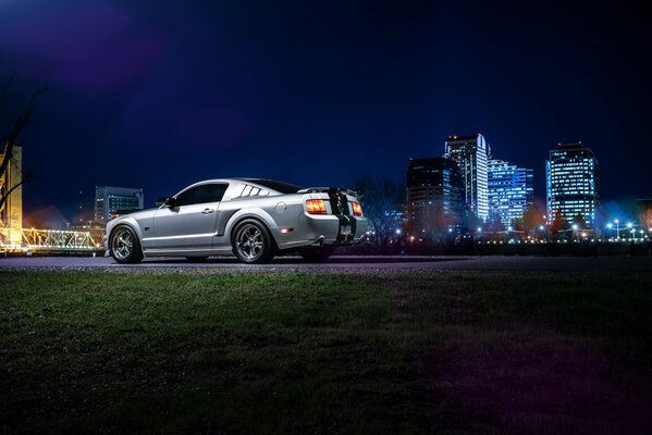 Steel-colored passenger car on the background of skyscrapers