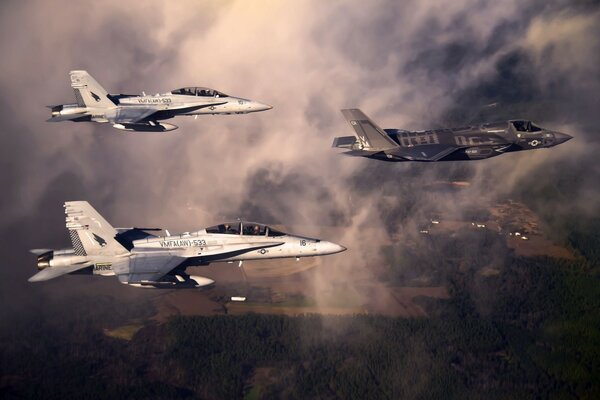 Tres aviones vuelan en nubes oscuras