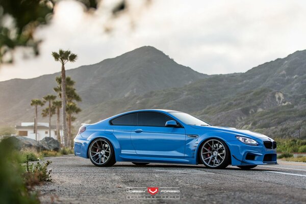 BMW azul en el fondo de las montañas