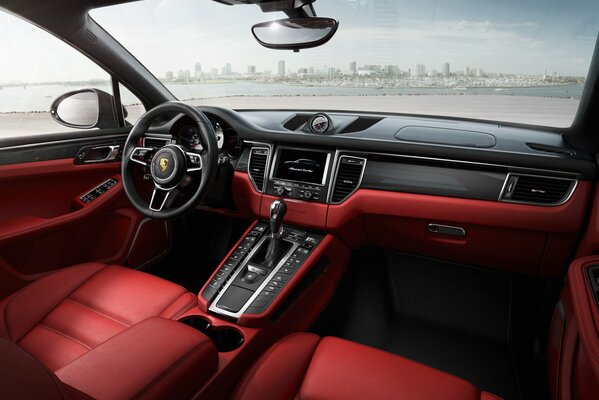 Porsche interior in red with a view of the modern city in the distance in the windshield