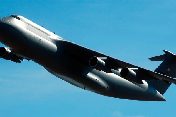 Avión militar negro Galaxy en el fondo del cielo azul