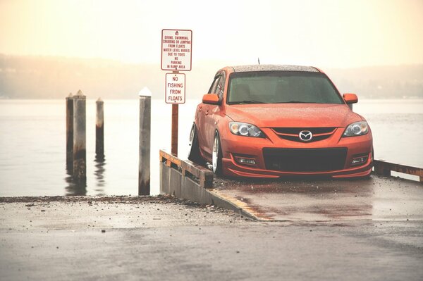 Orange getönter Mazda am Meer