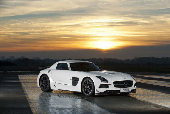 Mercedes-Benz SLS AMG blanc sur fond de coucher de soleil