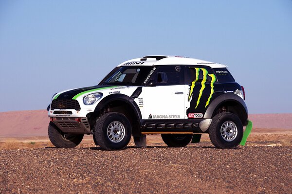 Dakar Rally. The SUV stands against the background of a hill and a blue sky