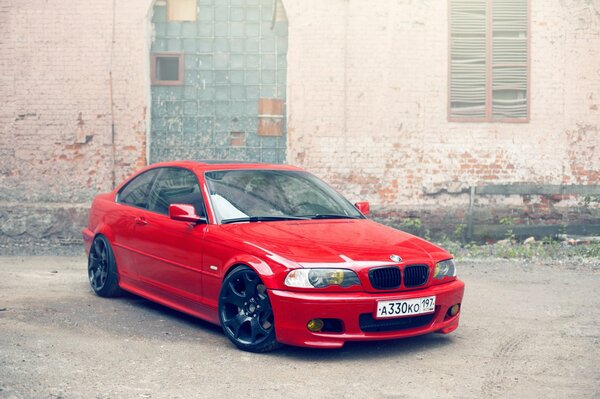 BMW rojo en el fondo de un edificio abandonado