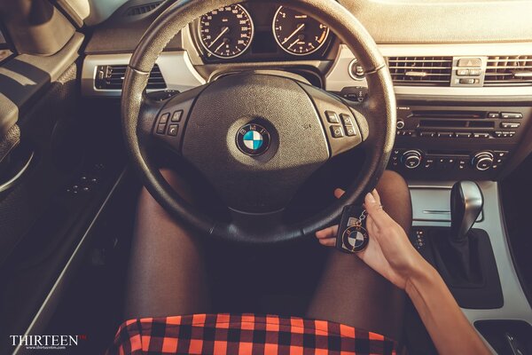 Fille avec des clés au volant d une BMW