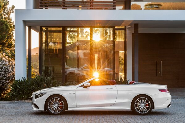 A white Mercedes convertible is reflected in the rays of the sun