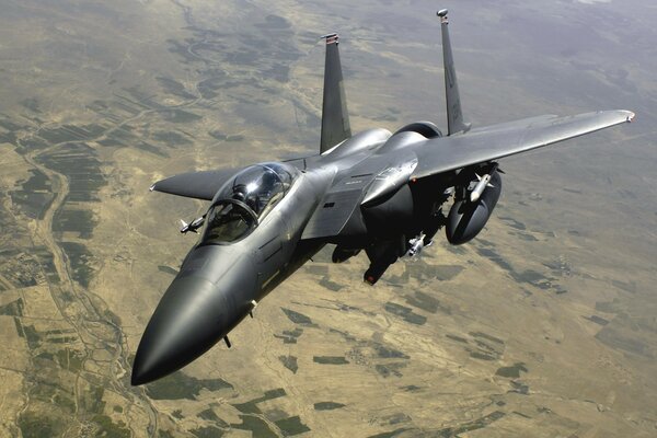 Grey f15 plane flying over the ground