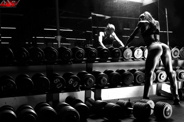 A girl in the gym with dumbbells