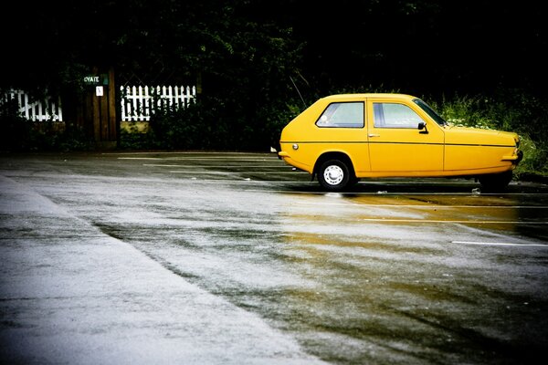 Yellow car on wet asphalt