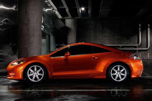 Red car, side view. In a dark room