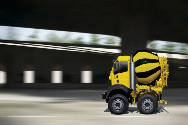 Bétonnière jaune à la vitesse sur la route