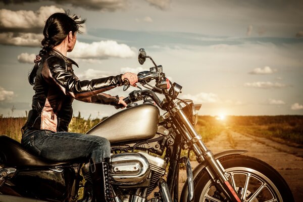 A girl on a motorcycle consisting of sunset