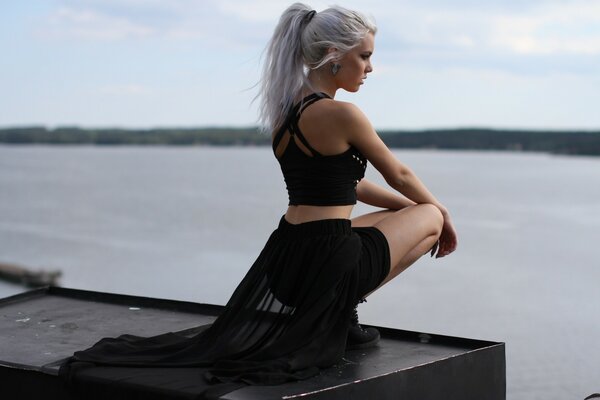 Sexy girl sitting near the water