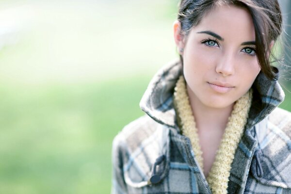 Green-eyed brunette in a plaid coat