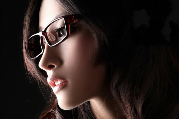 Fille asiatique avec des lunettes sur fond noir