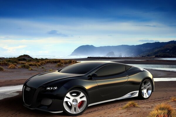 Audi on the riverbank against the background of fog and mountains 