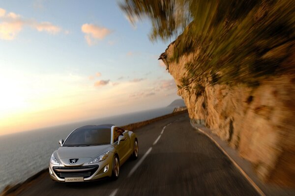 Peugeot drives along the road along the cliff