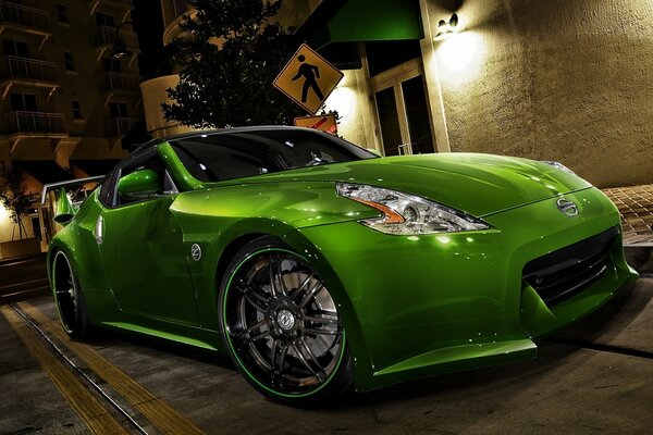 Voiture tuning verte dans la nuit à la lanterne