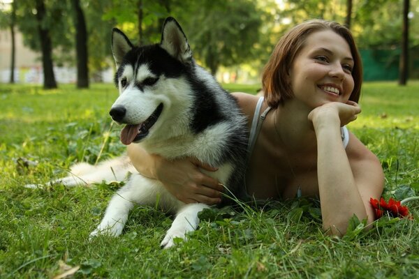 A girl with a dog lying on the grass