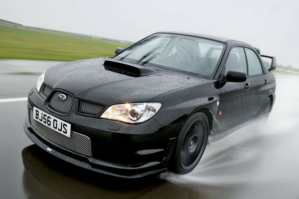 Subaru noir sur une route pluvieuse