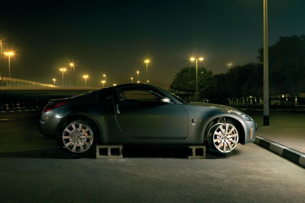 A Nissan car is parked on monoblocks without rubber