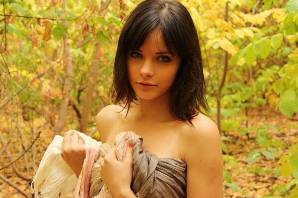 Brunette in a sheet against a forest background