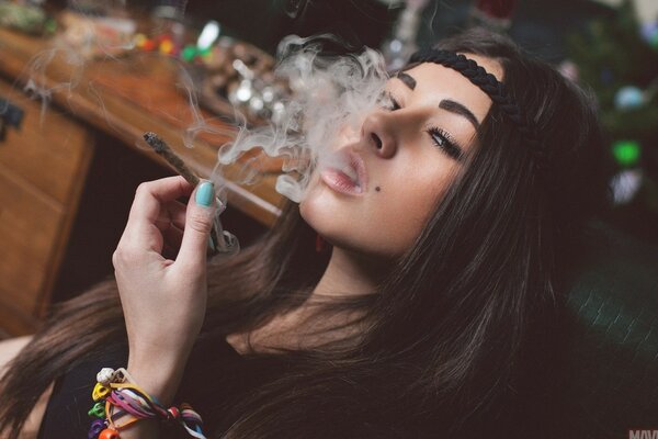 Beautiful brunette with a mole, smoking a cigarette, blowing smoke