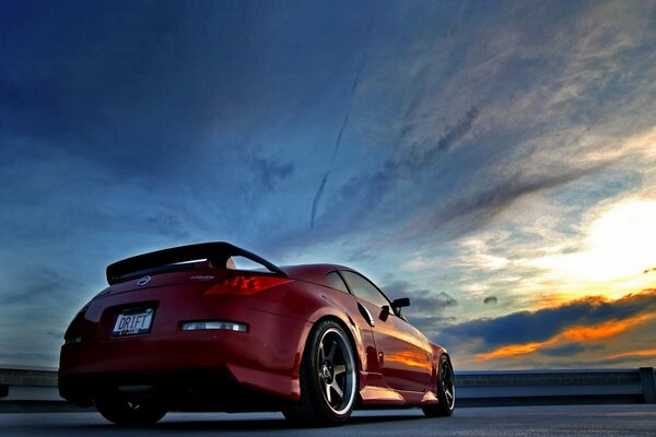 Red Nissan on the background of a beautiful sunset