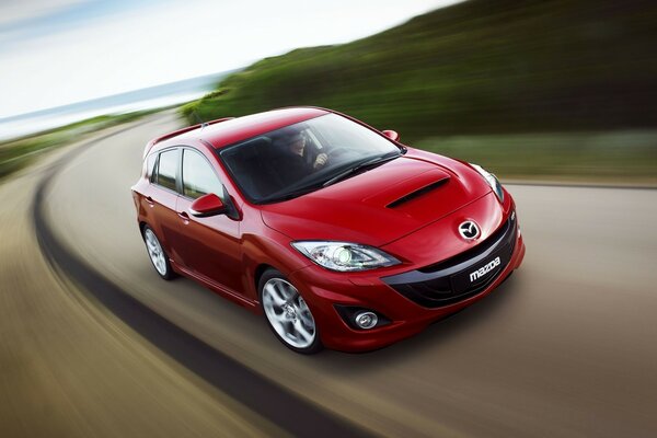 Red mazda 3 car on the road