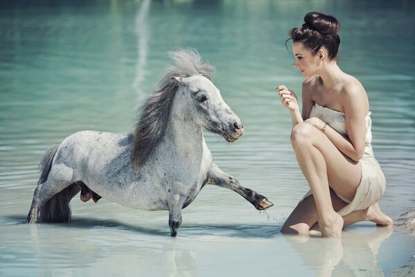 Mädchen und Pony im Wasser