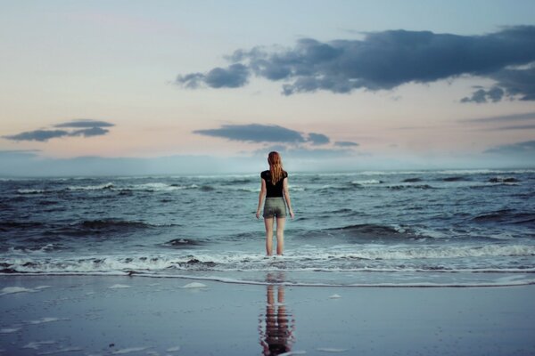 Das Mädchen und das Meer. Wellen kitzeln Ihre Beine