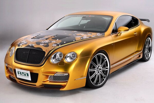 Bentley sintonizzata color oro con graffiti sul cofano