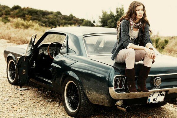 Chica sentada en un Mustang gris