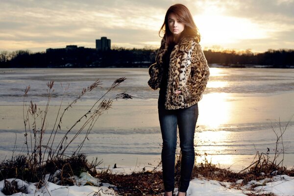 Beautiful girl by the river in winter