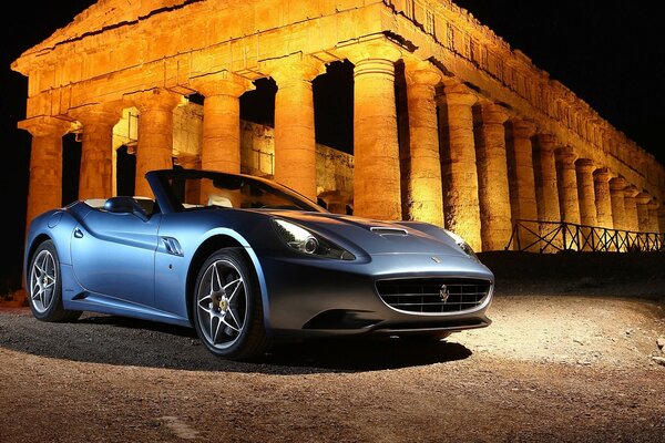 Blue ferrari with alloy wheels on the background of Ruins