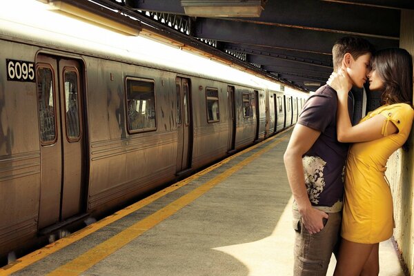 Pareja enamorada besándose cerca del tren