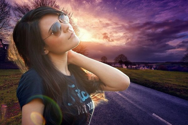 Girl on the background of the road in sunglasses