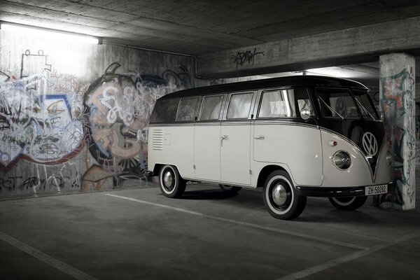 Biały volkswagen stoi w garażu na tle graffiti