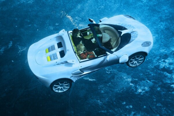 Imagen creativa de un convertible con dos personas bajo el agua